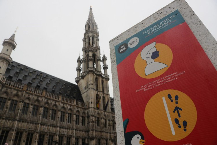 A poster showing measures against the COVID-19 is seen in the Grand Place in Brussels, Belgium, December 27, 2021. /Xinhua